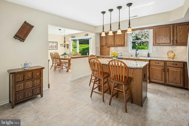 kitchen with a healthy amount of sunlight, backsplash, and brown cabinets