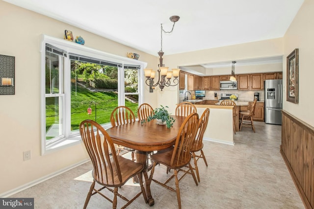 dining area with an inviting chandelier and baseboards