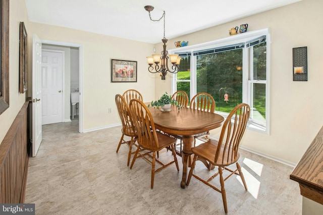 dining area featuring baseboards and a notable chandelier