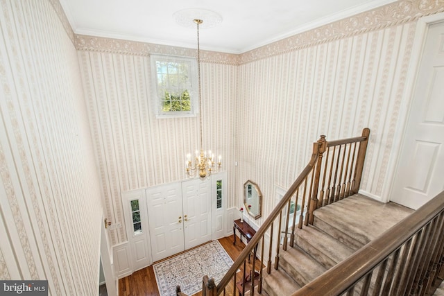 entryway featuring wallpapered walls, an inviting chandelier, and wood finished floors