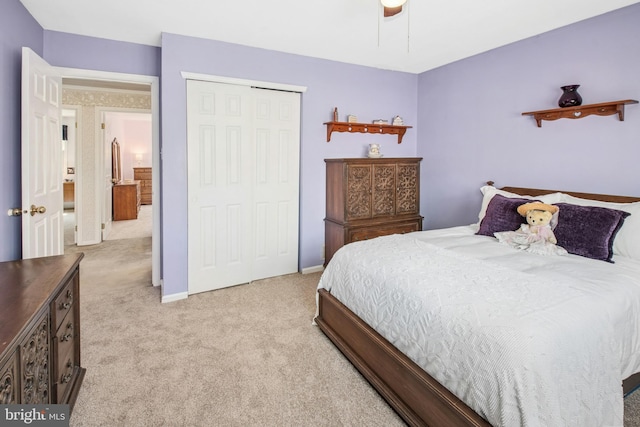 bedroom featuring a ceiling fan, baseboards, light carpet, and a closet