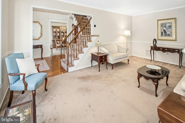 sitting room with visible vents, crown molding, baseboards, carpet flooring, and stairs