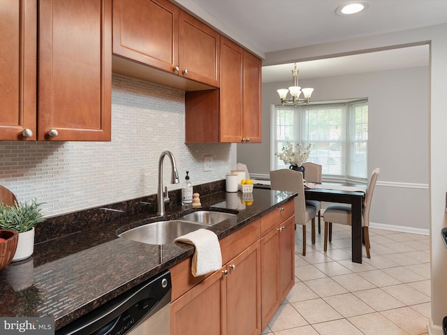 kitchen featuring light tile patterned floors, decorative backsplash, a sink, an inviting chandelier, and hanging light fixtures