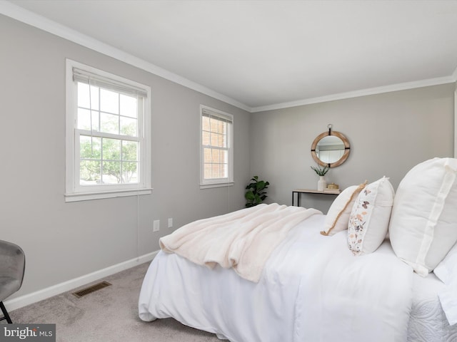 carpeted bedroom with baseboards, visible vents, and ornamental molding