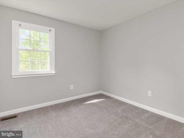 carpeted empty room with visible vents and baseboards