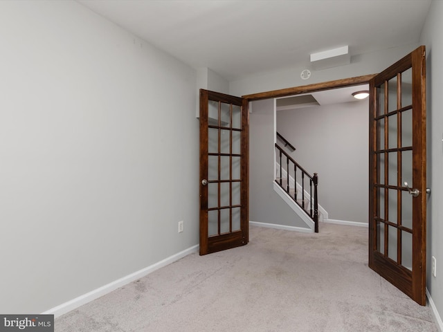 unfurnished room featuring baseboards, stairway, french doors, and carpet