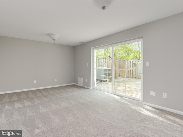 unfurnished room featuring baseboards, visible vents, and carpet flooring