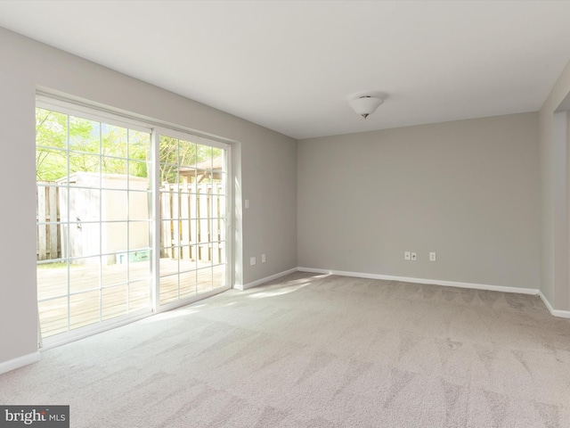 carpeted empty room with baseboards