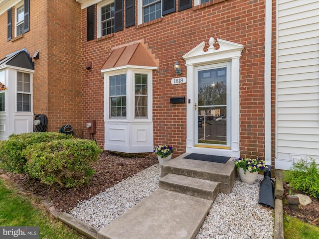 view of exterior entry with brick siding