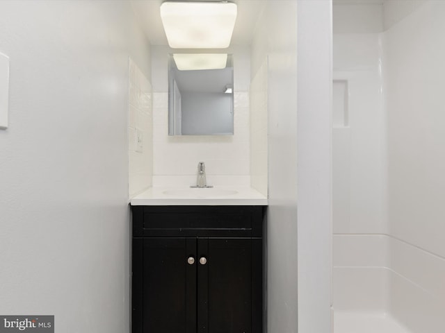 bathroom featuring walk in shower, vanity, and decorative backsplash
