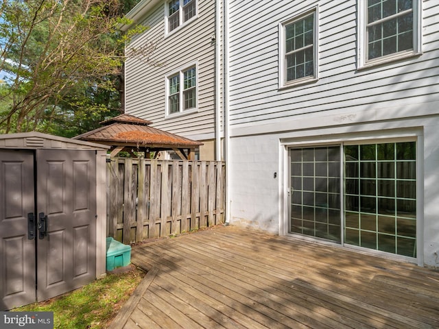wooden deck with an outbuilding, a storage shed, and a gazebo