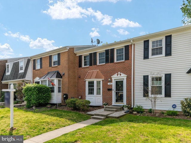 view of front of home featuring a front yard and brick siding