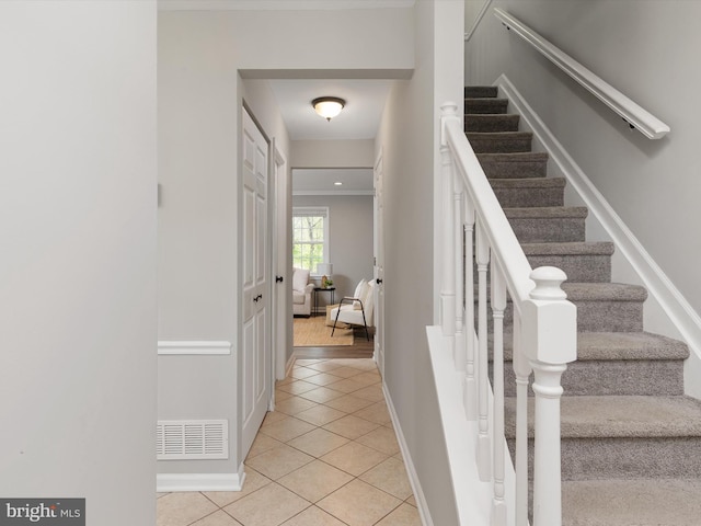 staircase with visible vents, tile patterned floors, and baseboards