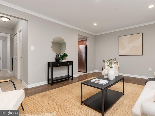 living room with wood finished floors, recessed lighting, ornamental molding, and baseboards
