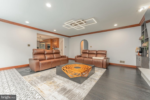 living room with baseboards, ornamental molding, recessed lighting, wood finished floors, and arched walkways