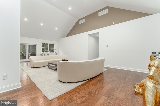 living area featuring high vaulted ceiling, wood finished floors, and recessed lighting