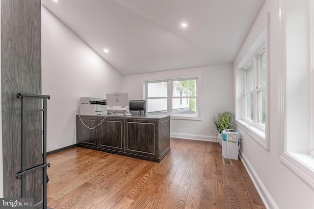 office area featuring lofted ceiling, light wood-style floors, and baseboards