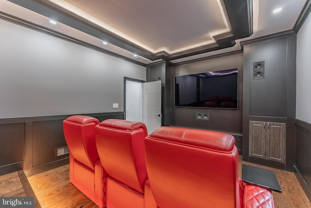cinema featuring wood finished floors, a decorative wall, a wainscoted wall, ornamental molding, and recessed lighting