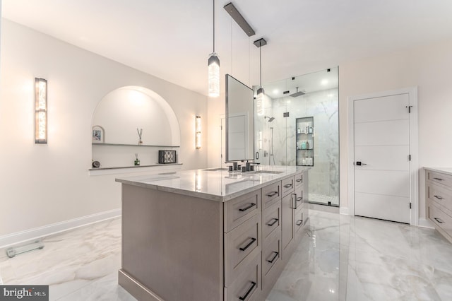 full bath featuring marble tiled floors, a marble finish shower, and vanity