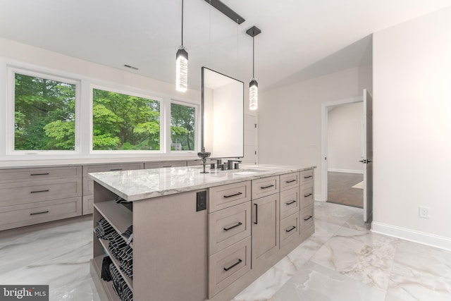 bathroom with healthy amount of natural light, baseboards, marble tiled flooring, and vanity