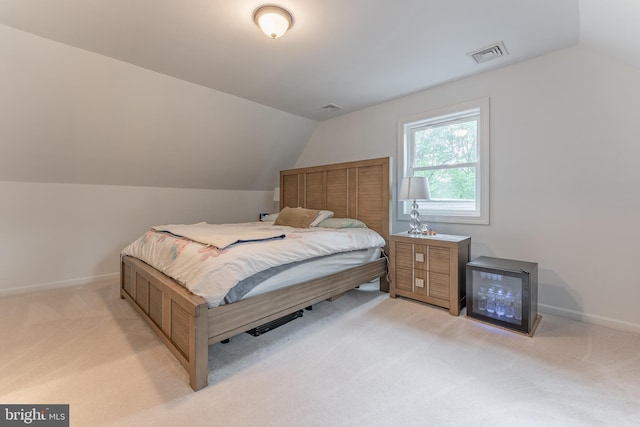 bedroom with vaulted ceiling, light colored carpet, and baseboards