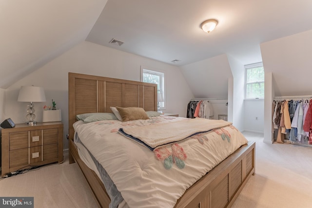 bedroom featuring light carpet and vaulted ceiling