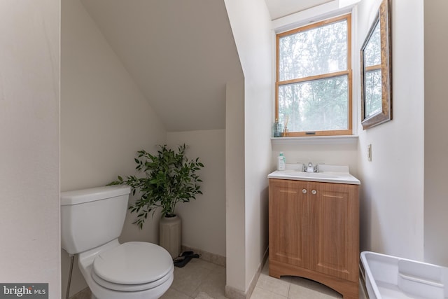 bathroom featuring toilet, tile patterned flooring, vanity, and lofted ceiling