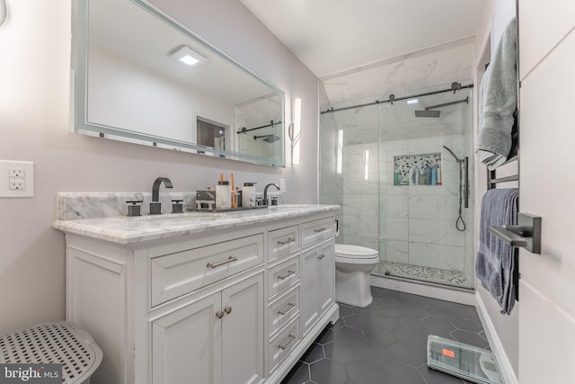 bathroom with a marble finish shower, double vanity, tile patterned floors, and toilet