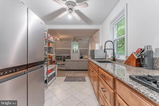 kitchen featuring a sink, ceiling fan, plenty of natural light, and light tile patterned floors