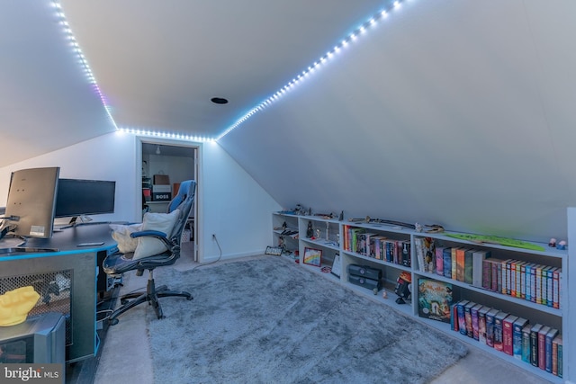 carpeted office space featuring lofted ceiling