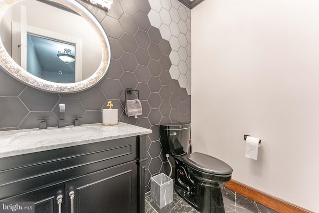 bathroom featuring tile walls, vanity, baseboards, and toilet