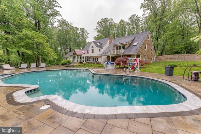 view of swimming pool with fence and a patio