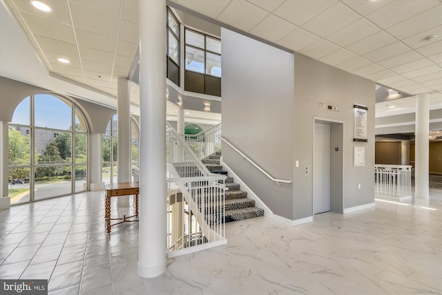stairway featuring baseboards, marble finish floor, recessed lighting, and elevator