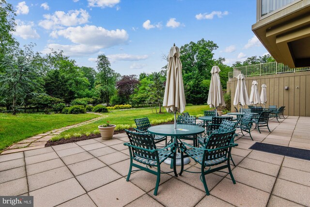 view of patio featuring a balcony and outdoor dining space