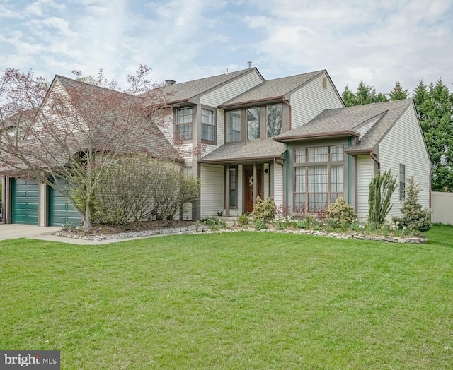 traditional home featuring a front yard, driveway, a garage, and roof with shingles