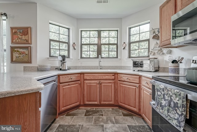 kitchen featuring a sink, stone finish flooring, visible vents, a toaster, and appliances with stainless steel finishes