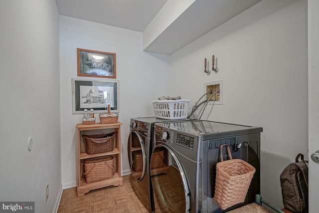 clothes washing area with washer and dryer, laundry area, and baseboards