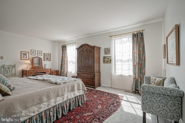 bedroom featuring multiple windows and light colored carpet