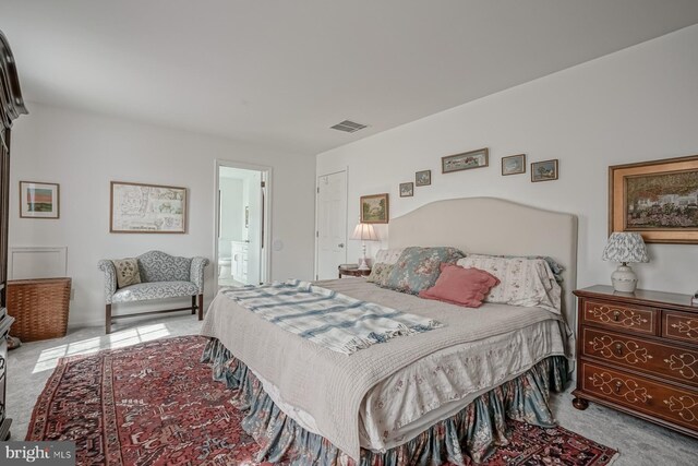 bedroom featuring carpet, visible vents, and ensuite bathroom