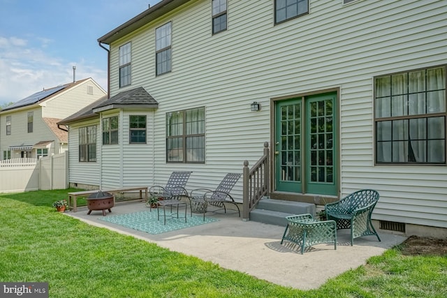 back of property featuring a fire pit, entry steps, a patio area, a lawn, and fence