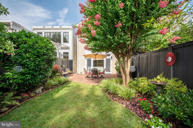 back of property featuring a lawn, a fenced backyard, and a patio area