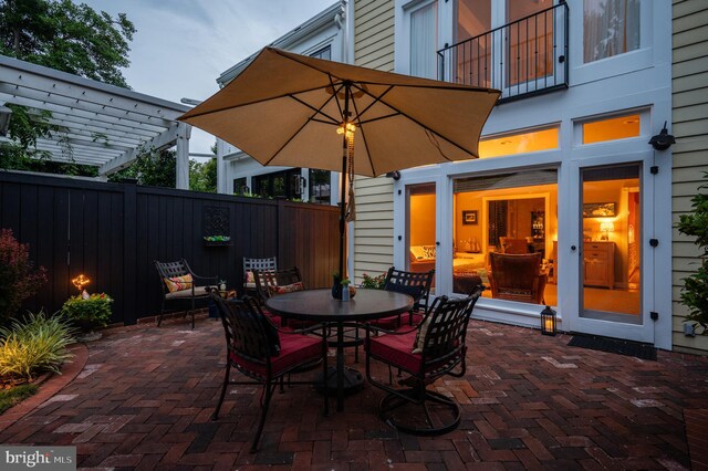 view of patio / terrace with outdoor dining area, a balcony, fence, and a pergola