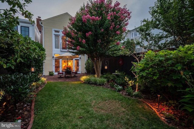 rear view of house featuring a yard and a patio