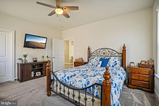 carpeted bedroom with ceiling fan and baseboards