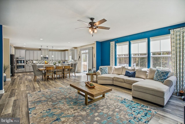 living area with ceiling fan and wood finished floors