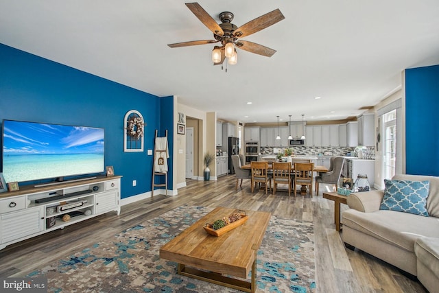 living room with baseboards, ceiling fan, recessed lighting, and wood finished floors