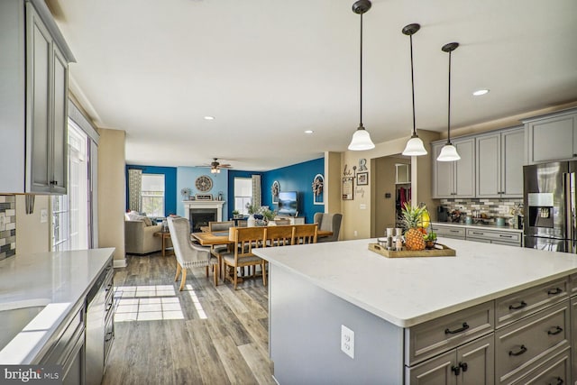 kitchen with ceiling fan, light wood-type flooring, gray cabinets, and tasteful backsplash