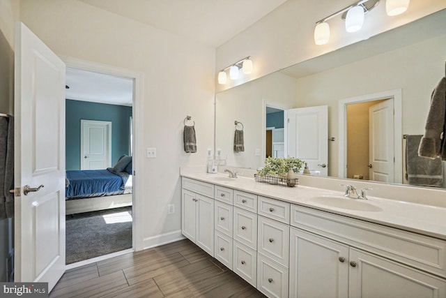 bathroom with a sink, wood finish floors, ensuite bath, and double vanity