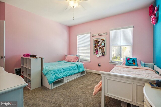 carpeted bedroom with ceiling fan and baseboards