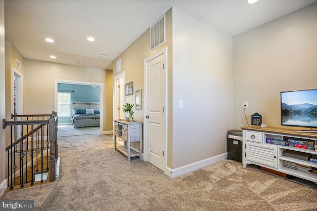 hall featuring carpet floors, visible vents, recessed lighting, and an upstairs landing